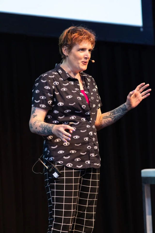 On stage at CSS Day, wearing black-and-white patterns and a headset